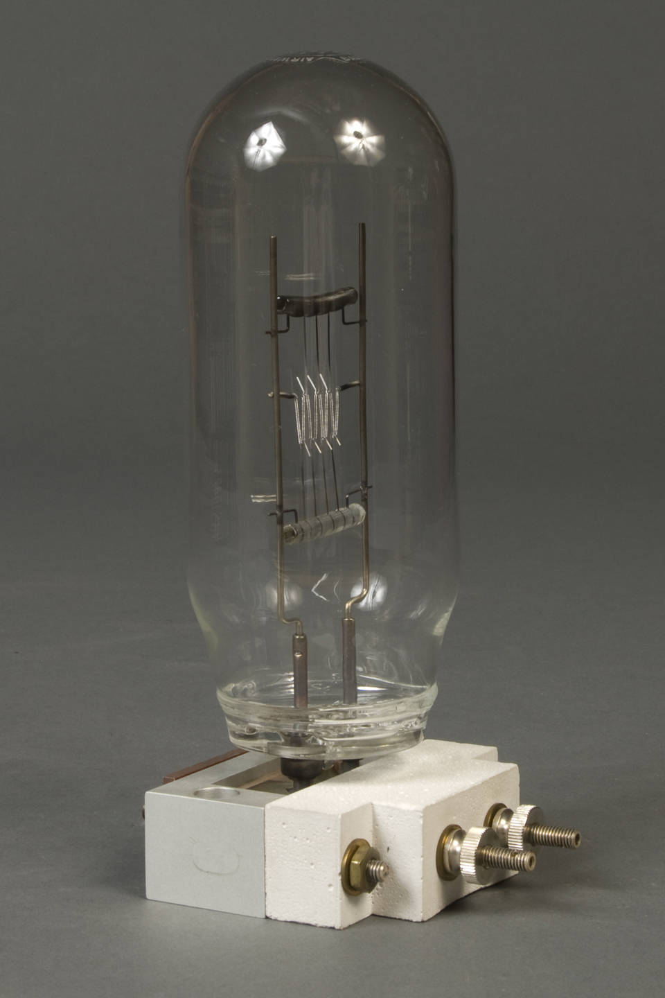 Unlit gas-filled incandescent standard lamp showing its filament inside a tall clear glass envelope