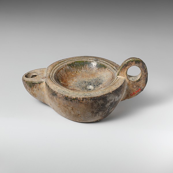 Unlit shallow Roman terracotta oil lamp with a handle and wick nozzle